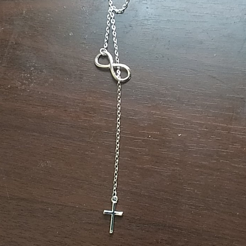 Silver necklace with cross and infinity charm.